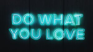 Turquoise neon sign that reads 'do what you love'.