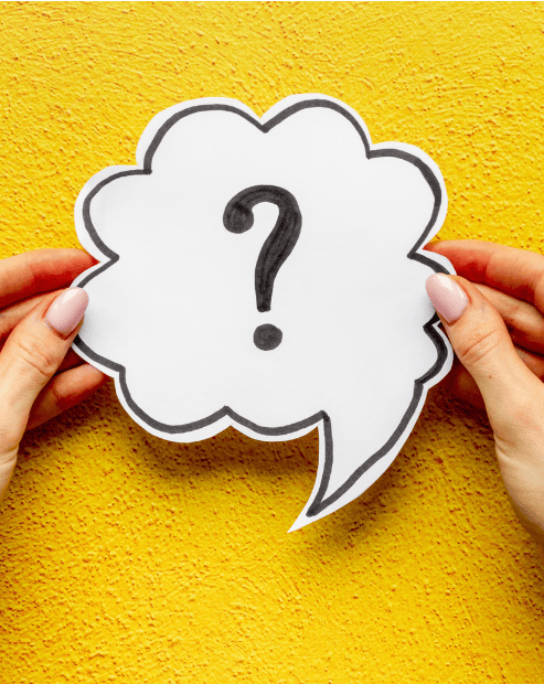 Small hero image promoting the Purpose and Profit business structure workshop. A bright and energetic image showing a pair of hands holding a white paper speech bubble against a vivid, textured yellow background. Inside the speech bubble, a large, black hand-drawn question mark is centred. The person’s hands are visible on the left and right edges, with light pink manicured nails, firmly gripping the cutout.